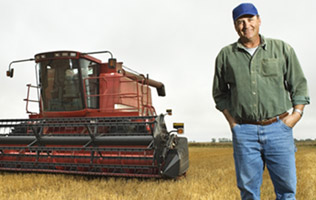 farmer standing in front of a harvester